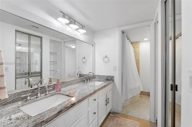 a bathroom with a granite countertop sink and a mirror