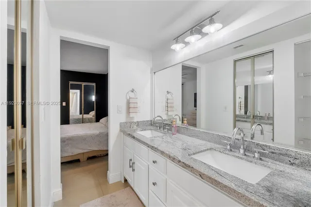 a en suite bathroom with a granite countertop sink and a mirror