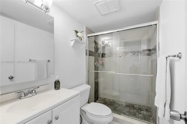 a bathroom with a sink mirror toilet and shower