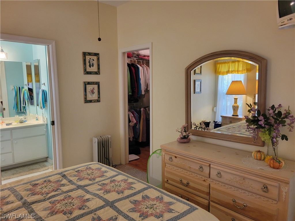 10720 Blue Bimini Circle Estero, FL 33928 - Photo 11 of 28 a bedroom with a bed and a mirror on dresser