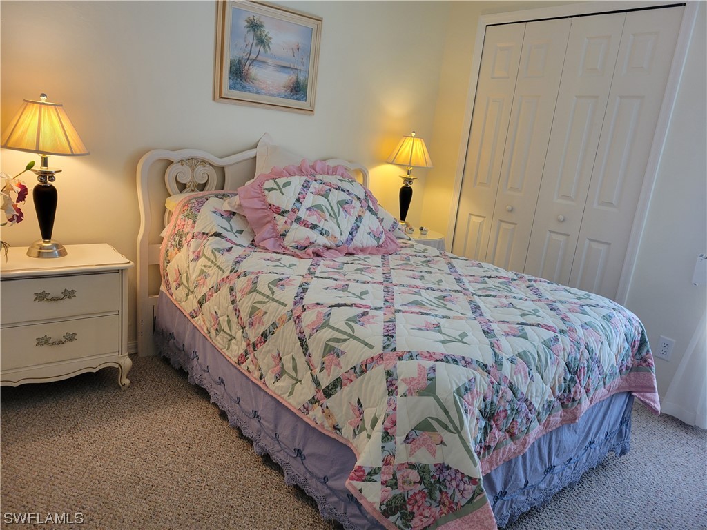 10720 Blue Bimini Circle Estero, FL 33928 - Photo 15 of 28 a bed sitting in a bedroom next to a lamp