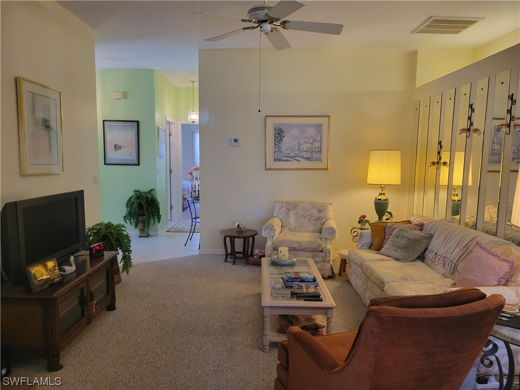 10720 Blue Bimini Circle Estero, FL 33928 - Photo 2 of 28 a living room with furniture and a flat screen tv