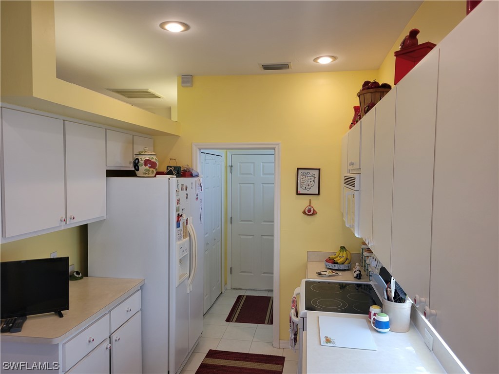10720 Blue Bimini Circle Estero, FL 33928 - Photo 8 of 28 a kitchen with a refrigerator and a stove top oven