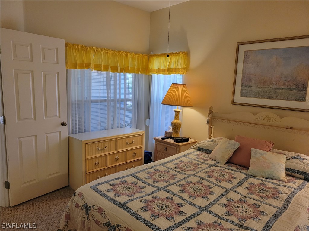 10720 Blue Bimini Circle Estero, FL 33928 - Photo 10 of 28 a bedroom with a bed and a lamp