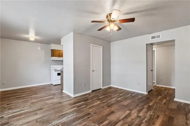 a view of empty room with wooden floor