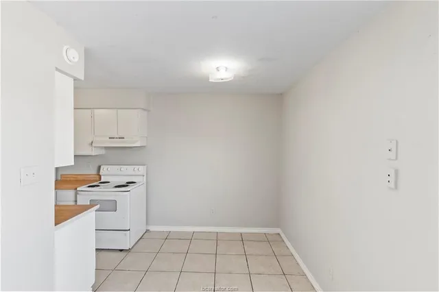 a kitchen with white cabinets and appliances