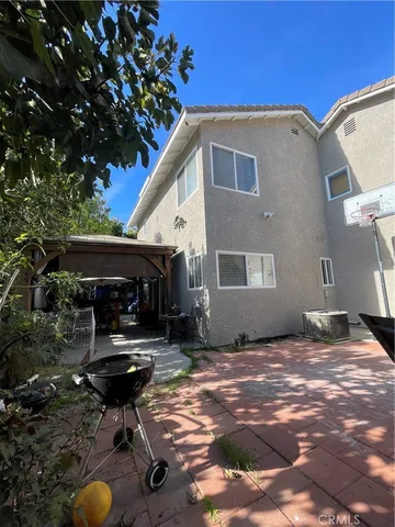 a backyard of a house with barbeque oven table and chairs