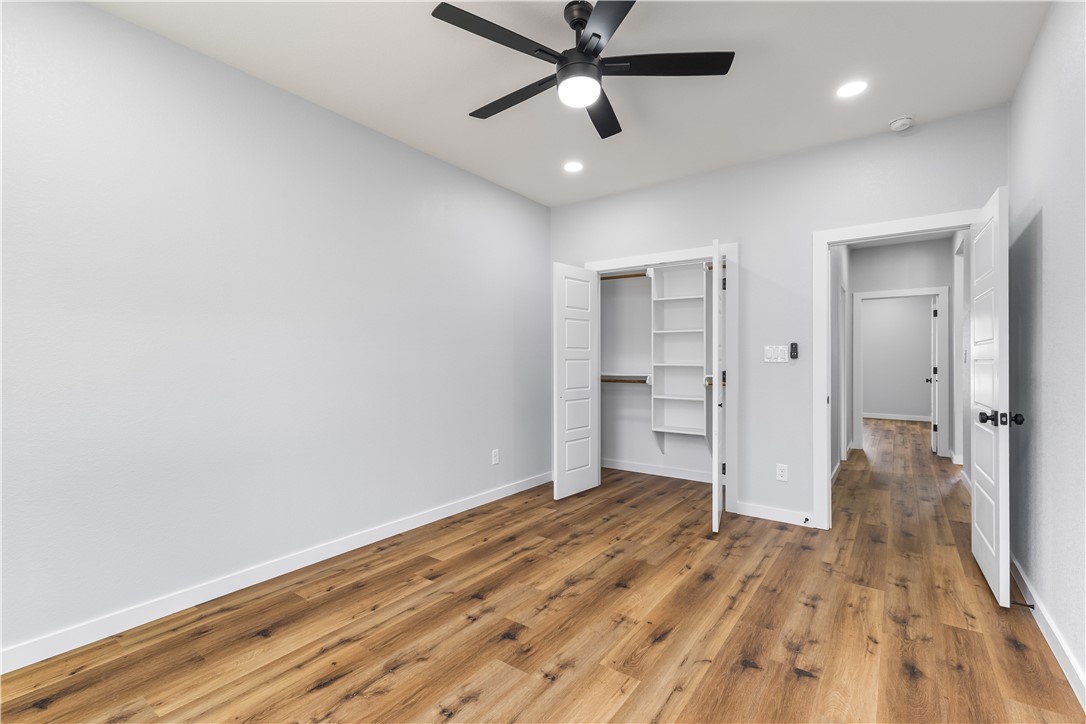 308 Crye Circle Winters, TX 79567 - Photo 39 of 44 a view of a room with wooden floor and a ceiling fan