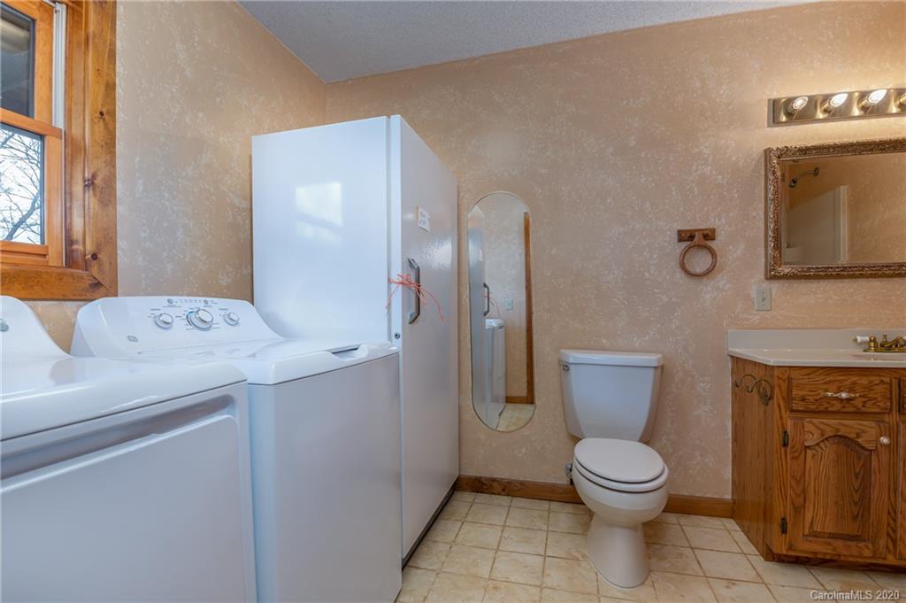 83 Luther Durham Road Tryon, NC 28782 - Photo 36 of 43 a spacious bathroom with a toilet sink and mirror
