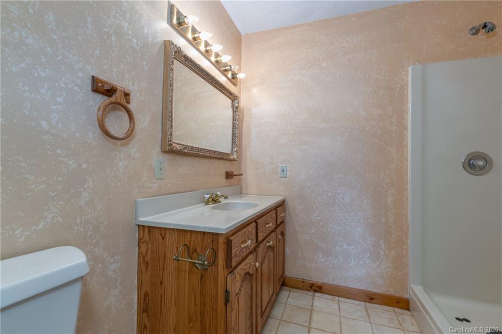 83 Luther Durham Road Tryon, NC 28782 - Photo 37 of 43 a bathroom with a sink a toilet and mirror