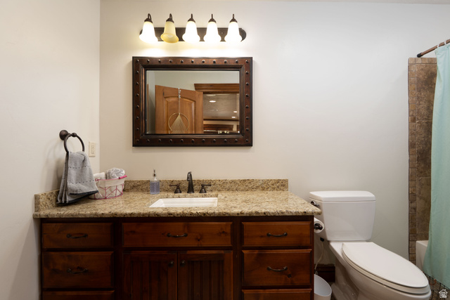 687 South 2080th Street East Springville, UT 84663 - Photo 51 of 149 Bathroom vanity featuring a granite countertop, undermount sink, and dark wood cabinetry with drawers