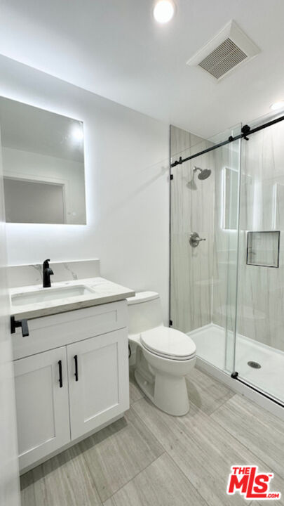 1339 South Hudson Avenue Los Angeles, CA 90019 - Photo 11 of 17 a bathroom with a sink toilet and shower
