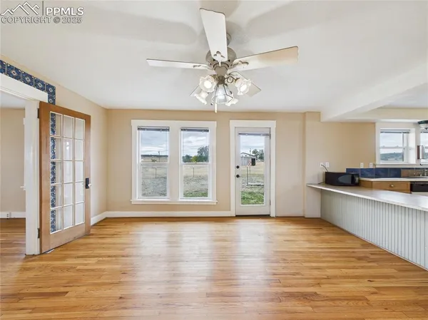 a view of an empty room with window and wooden floor