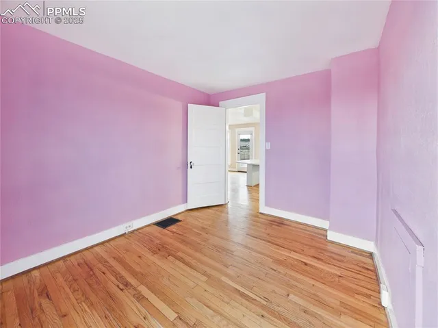 a view of an empty room with wooden floor