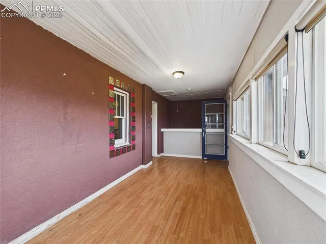 a view of a hallway with wooden floor and cabinet