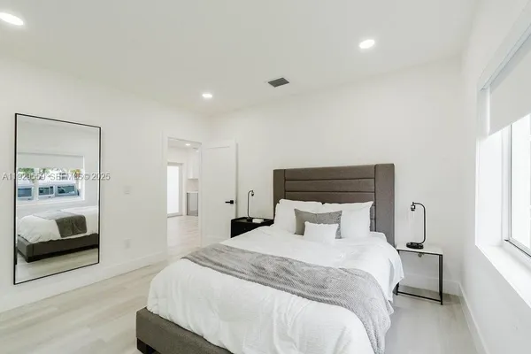 a bedroom with a bed and a painting on the wall