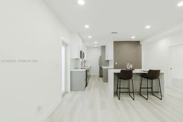 a kitchen with stainless steel appliances a stove a sink and a refrigerator
