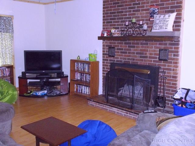 2841 Glade Valley Road Sparta, NC 28675 - Photo 11 of 15 a living room with furniture a flat screen tv and a fireplace