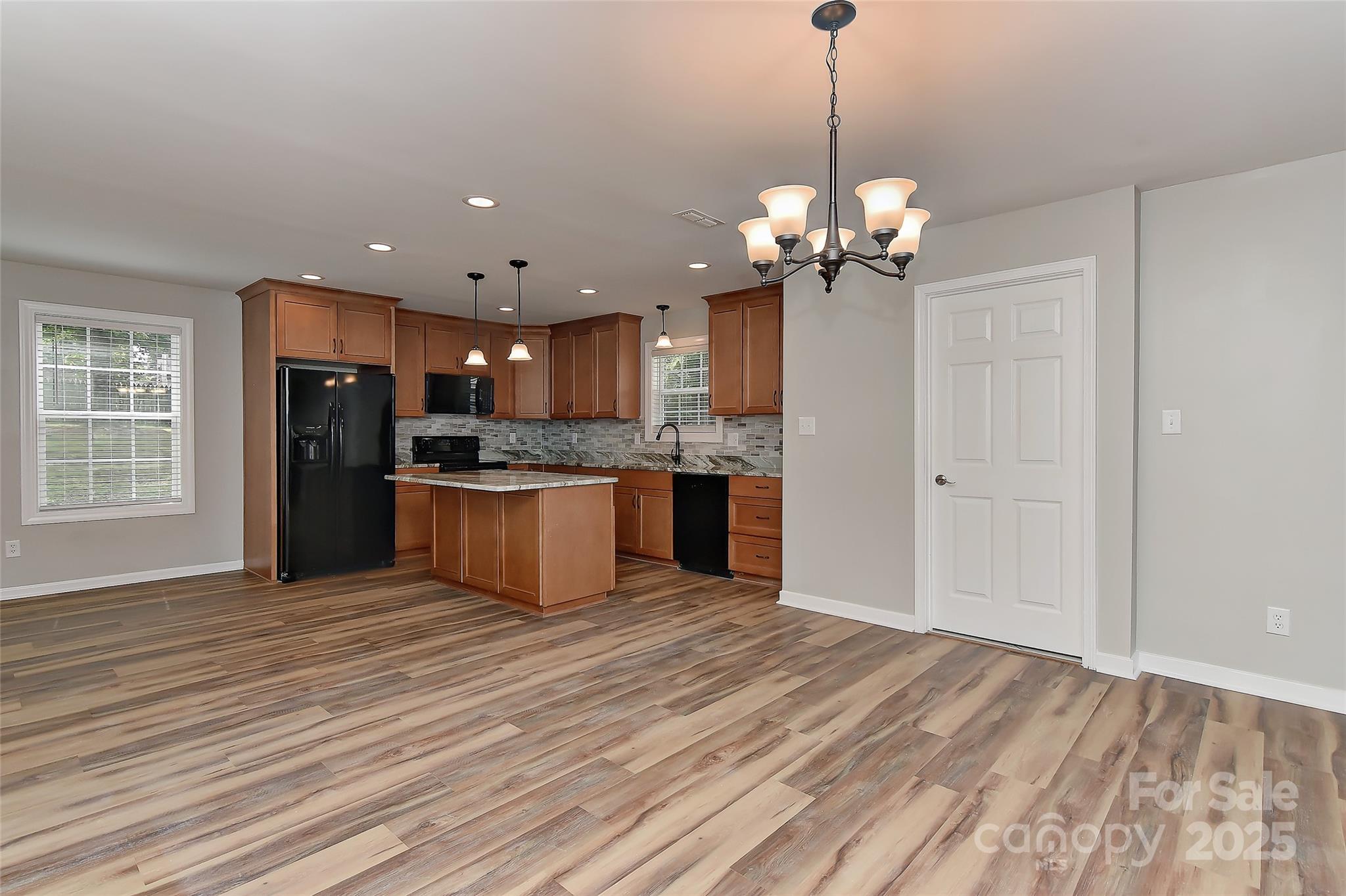 8056 Hunley Ridge Road Matthews, NC 28104 - Photo 3 of 37 a view of a kitchen with granite countertop stainless steel appliances and wooden floor