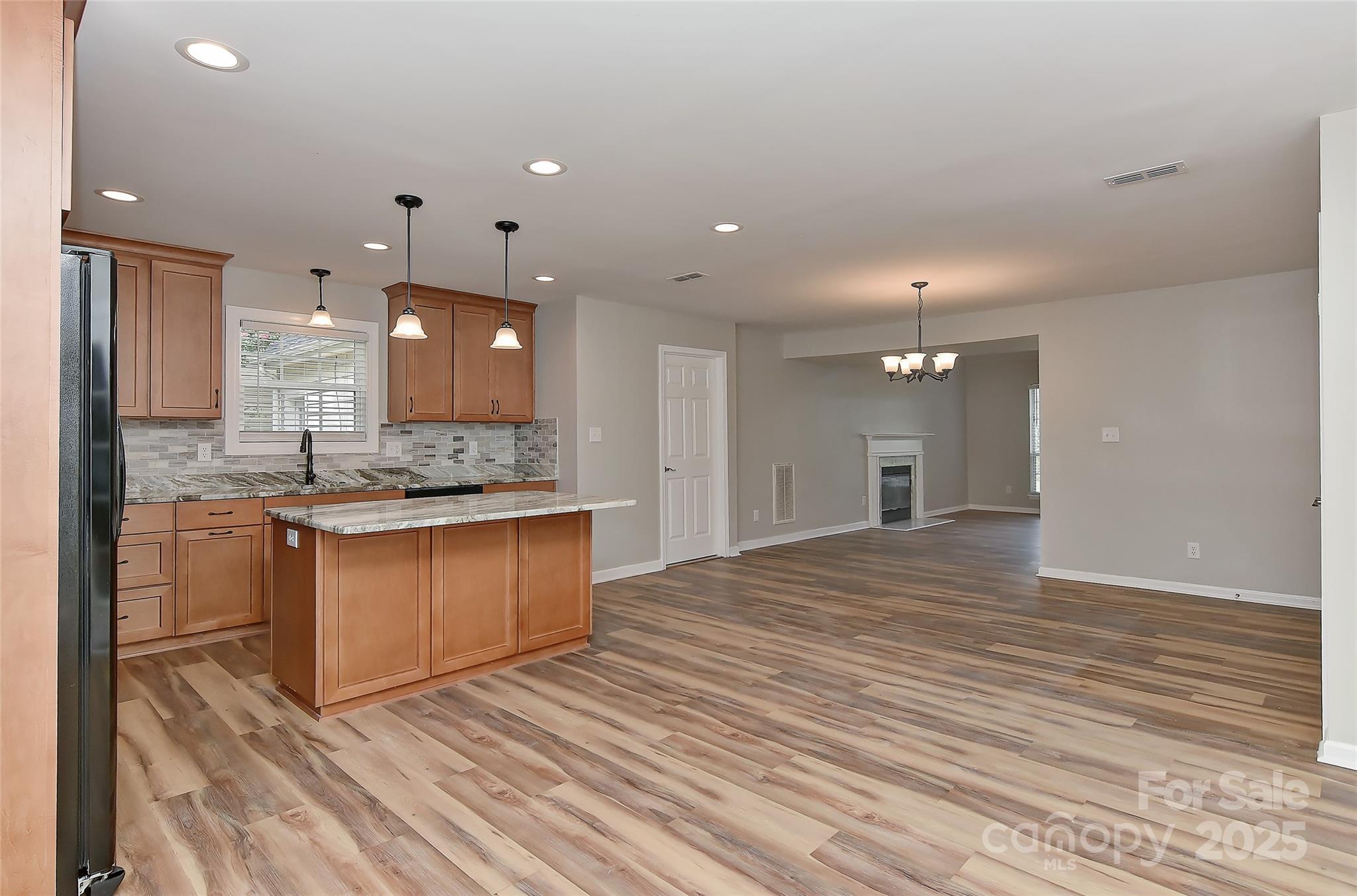 8056 Hunley Ridge Road Matthews, NC 28104 - Photo 5 of 37 a large kitchen with granite countertop a large counter top a sink stainless steel appliances and cabinets