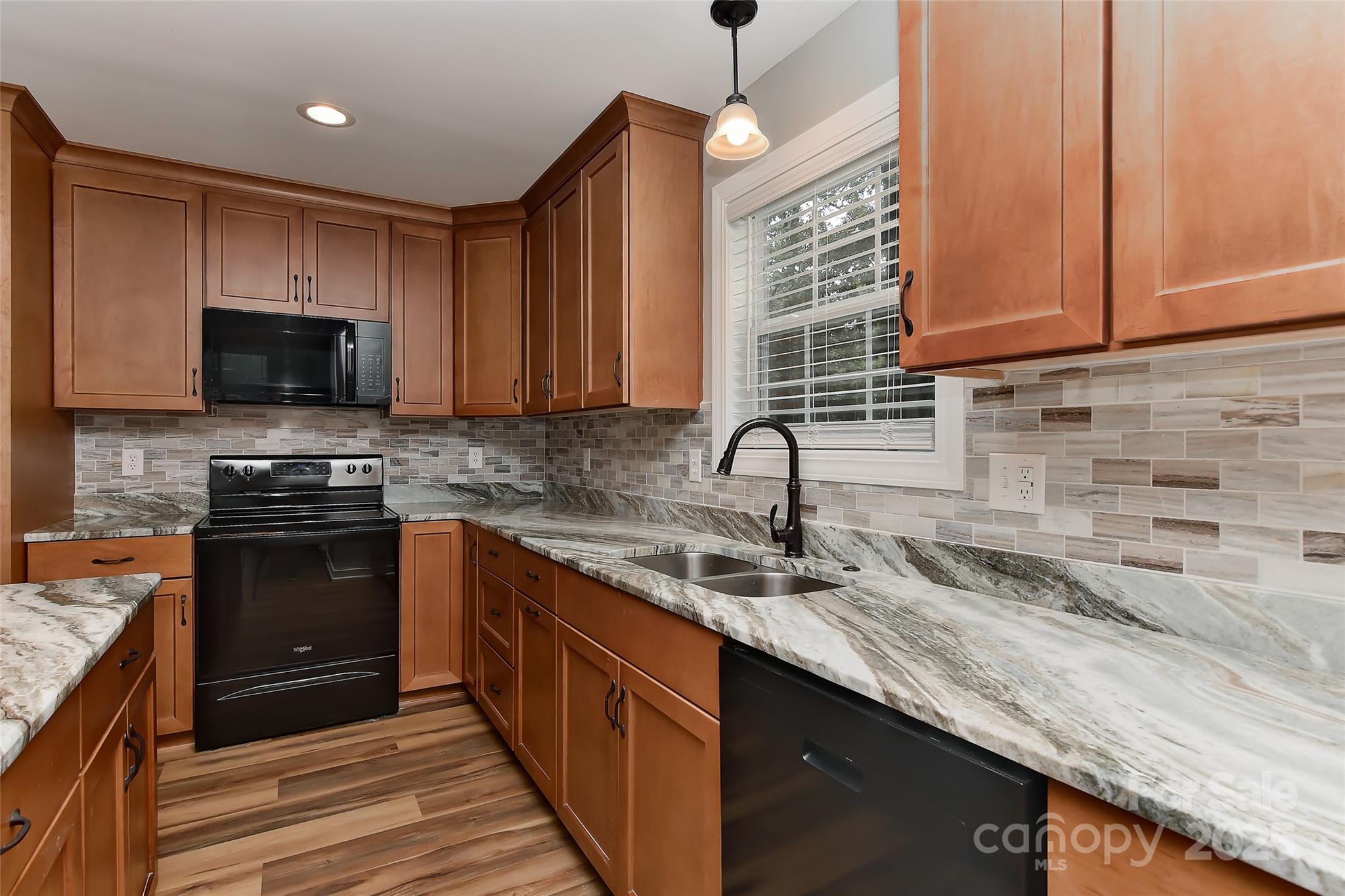 8056 Hunley Ridge Road Matthews, NC 28104 - Photo 7 of 37 a kitchen with stainless steel appliances granite countertop a sink a stove and a microwave