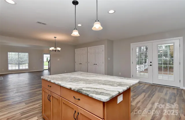 a kitchen with kitchen island granite countertop wooden cabinets and a refrigerator