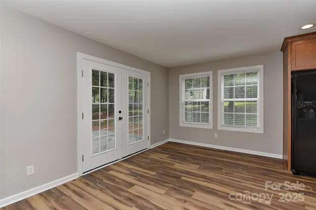 a view of a livingroom with a chandelier fan and wooden floor