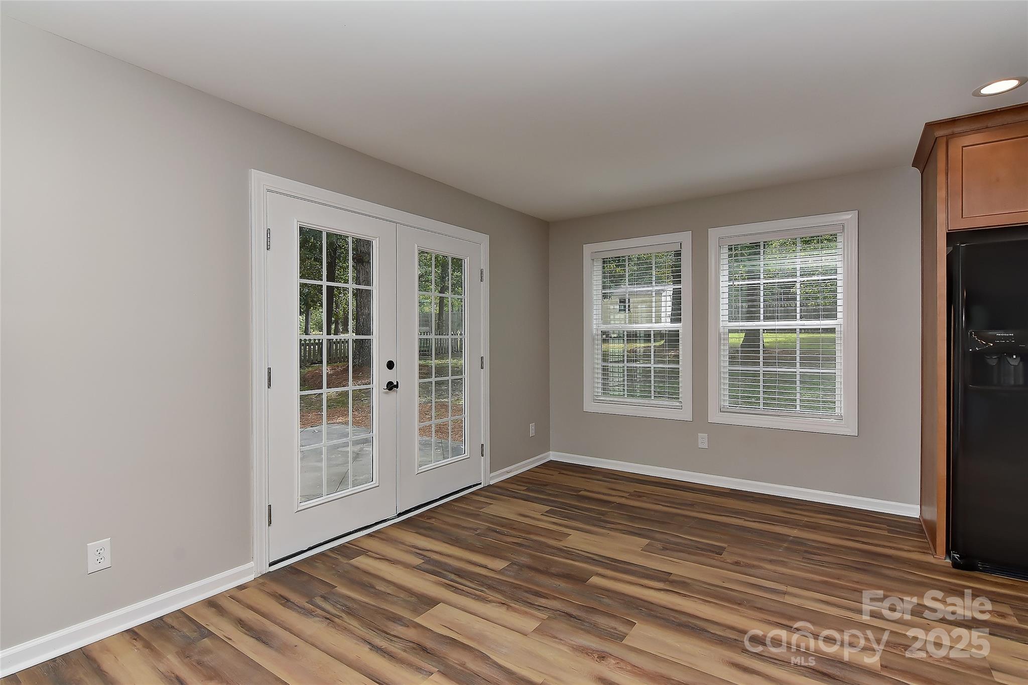 8056 Hunley Ridge Road Matthews, NC 28104 - Photo 10 of 37 an empty room with wooden floor and windows