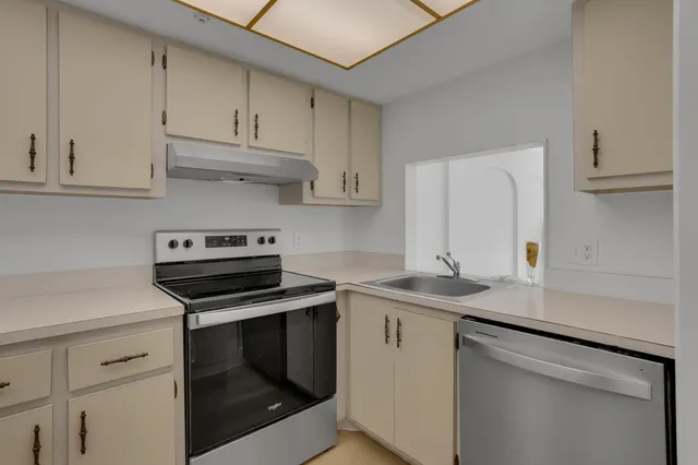 a kitchen with stainless steel appliances granite countertop a sink stove and cabinets