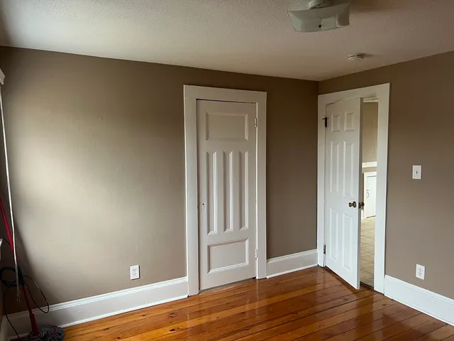 an empty room with wooden floor and closet