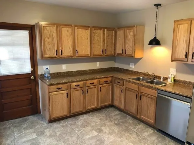 a kitchen with stainless steel appliances granite countertop a sink a stove and a refrigerator