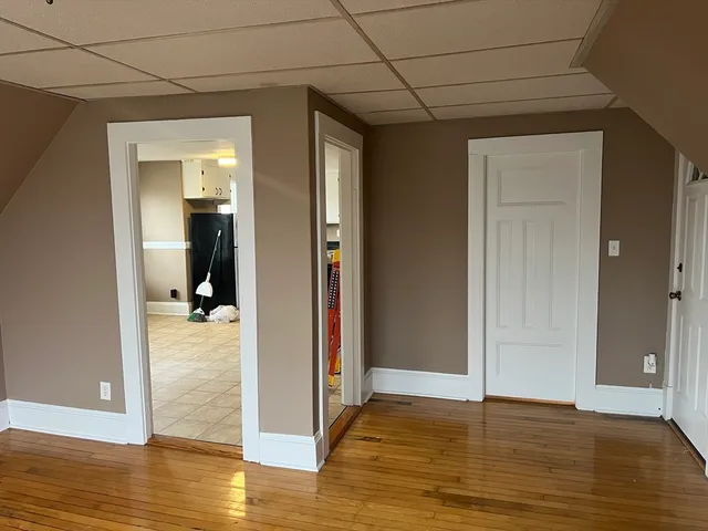 a view of empty room with wooden floor