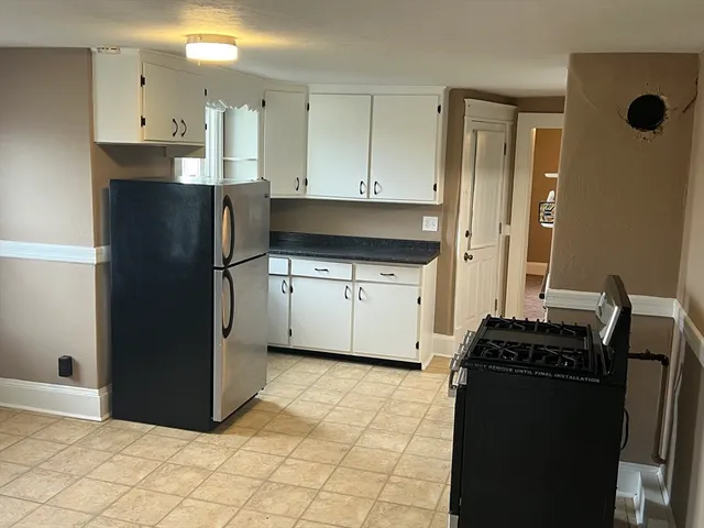 a kitchen with stainless steel appliances granite countertop a refrigerator and a stove