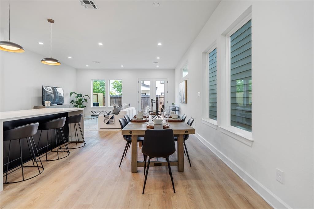6321 Foster Street Houston, TX 77021 - Photo 5 of 19 Open-concept dining and living area with sleek hardwood floors, modern pendant lighting, and expansive windows for abundant natural light.