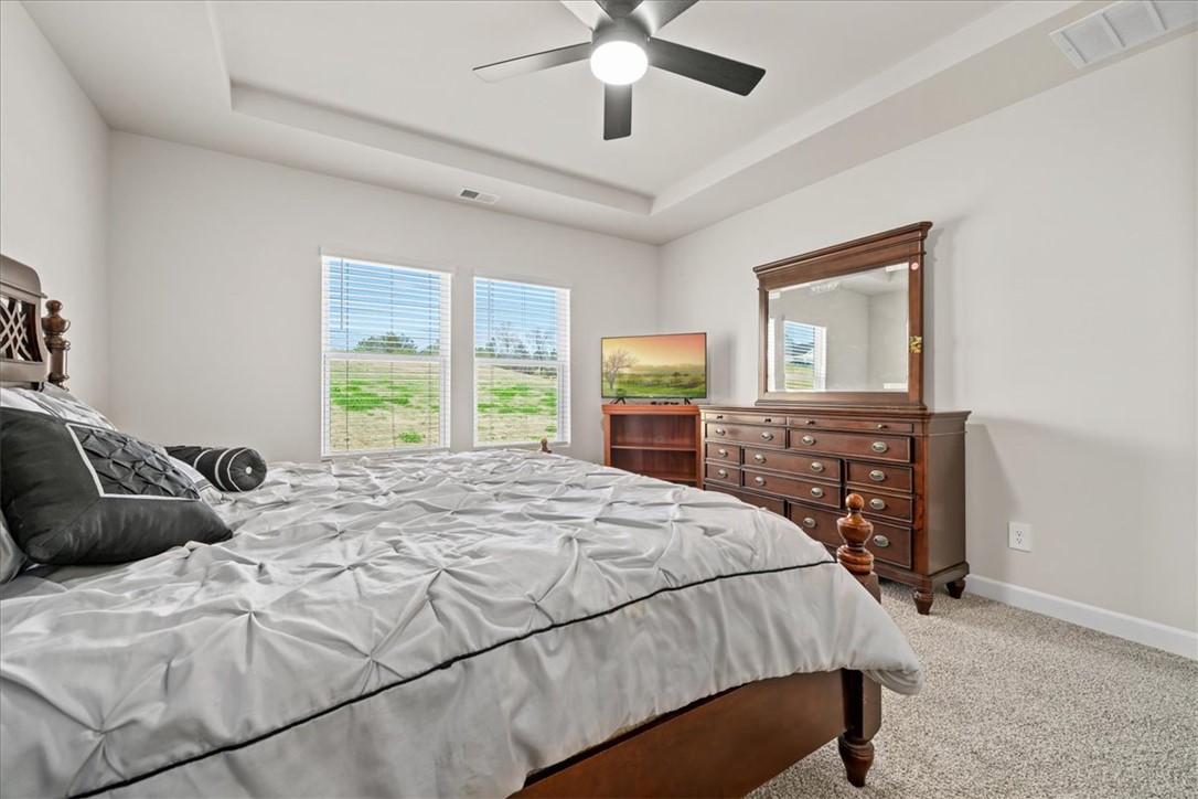 106 Purcell Way Easley, SC 29642 - Photo 18 of 39 This inviting bedroom features a tray ceiling, ceiling fan, and ample natural light.
