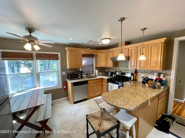a kitchen with refrigerator a stove and a kitchen island