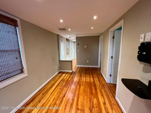 a view of a livingroom with wooden floor and staircase