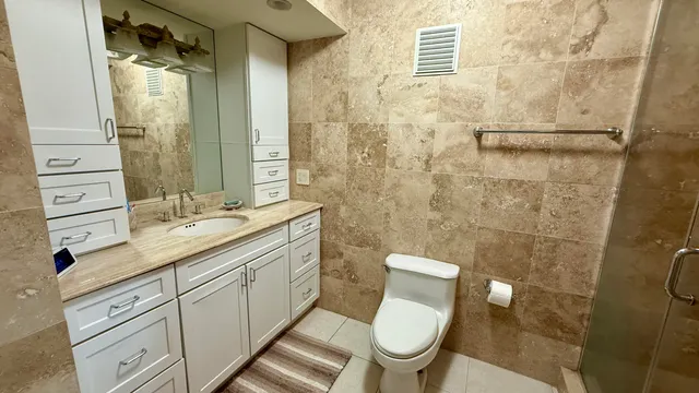 a bathroom with a granite countertop toilet sink and a shower