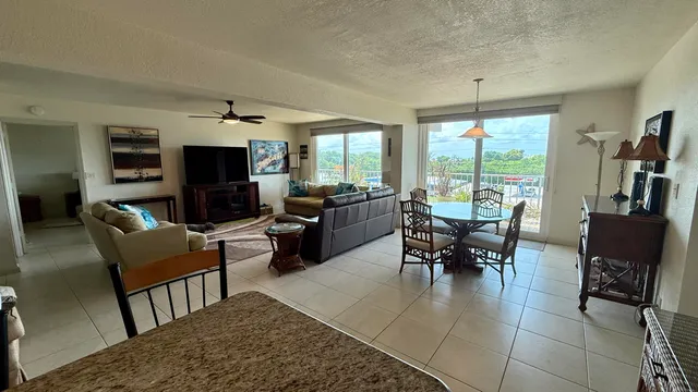 a living room with furniture a fireplace a flat screen tv and a large window
