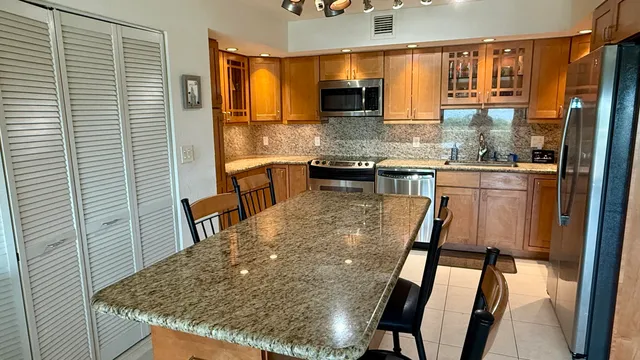 a kitchen with stainless steel appliances granite countertop wooden cabinets and sink