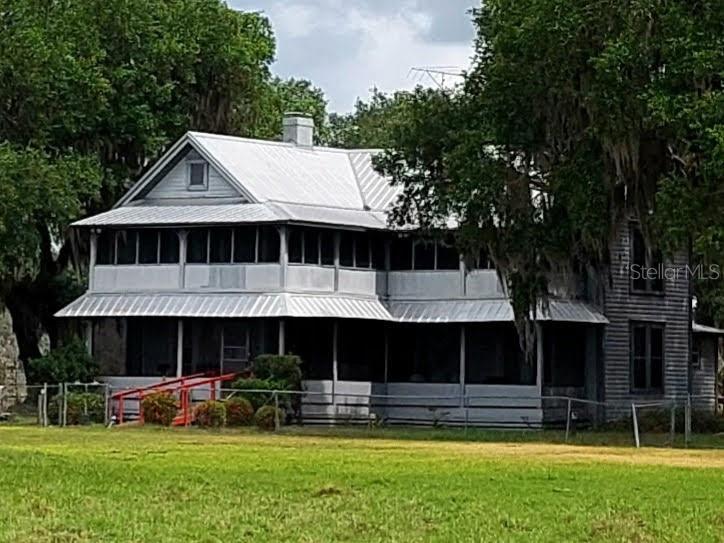 3650 Lake Tohopekaliga Road St. Cloud, FL 34772 - Photo 11 of 61 a front view of a house with a yard table and chairs