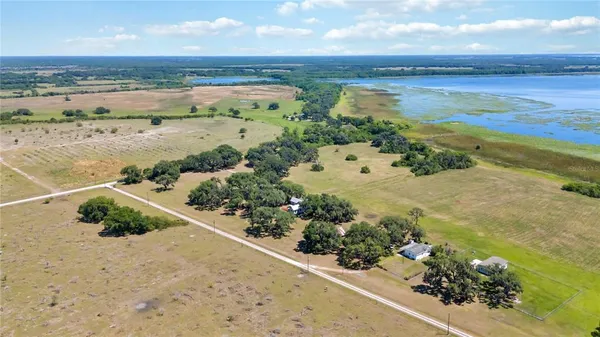 a view of a field with a trees in the background