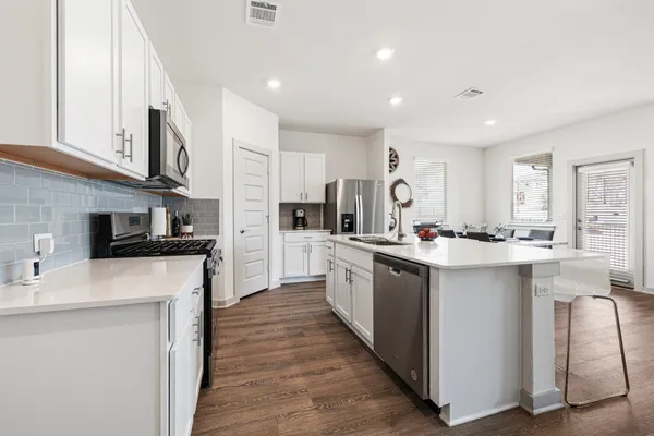 a kitchen with stainless steel appliances granite countertop a sink stove and refrigerator