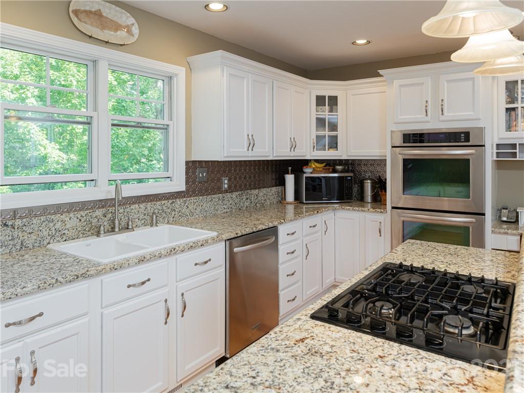 10 Powder Ridge Drive Asheville, NC 28803 - Photo 19 of 46 a kitchen with granite countertop a sink stainless steel appliances and white cabinets
