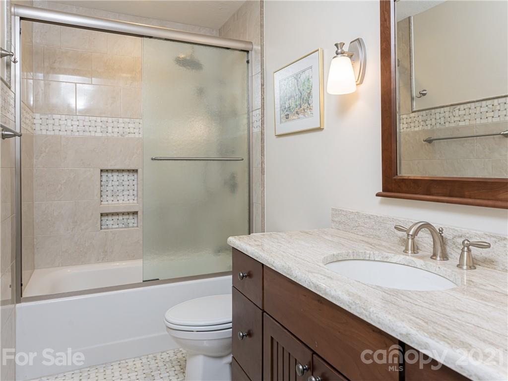 10 Powder Ridge Drive Asheville, NC 28803 - Photo 27 of 46 a bathroom with a granite countertop sink toilet and shower