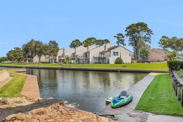 a view of a lake with a yard and large trees