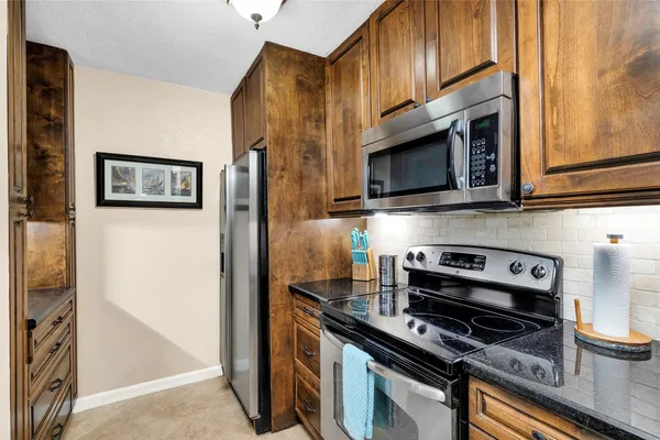 a kitchen with stainless steel appliances a stove a microwave and wood cabinets