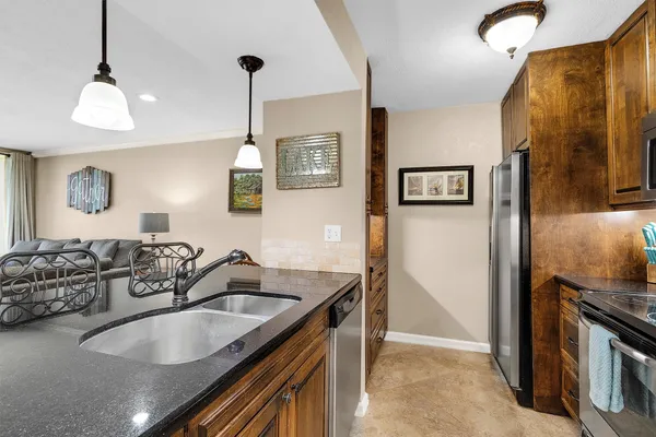 a kitchen with stainless steel appliances granite countertop a sink and a refrigerator