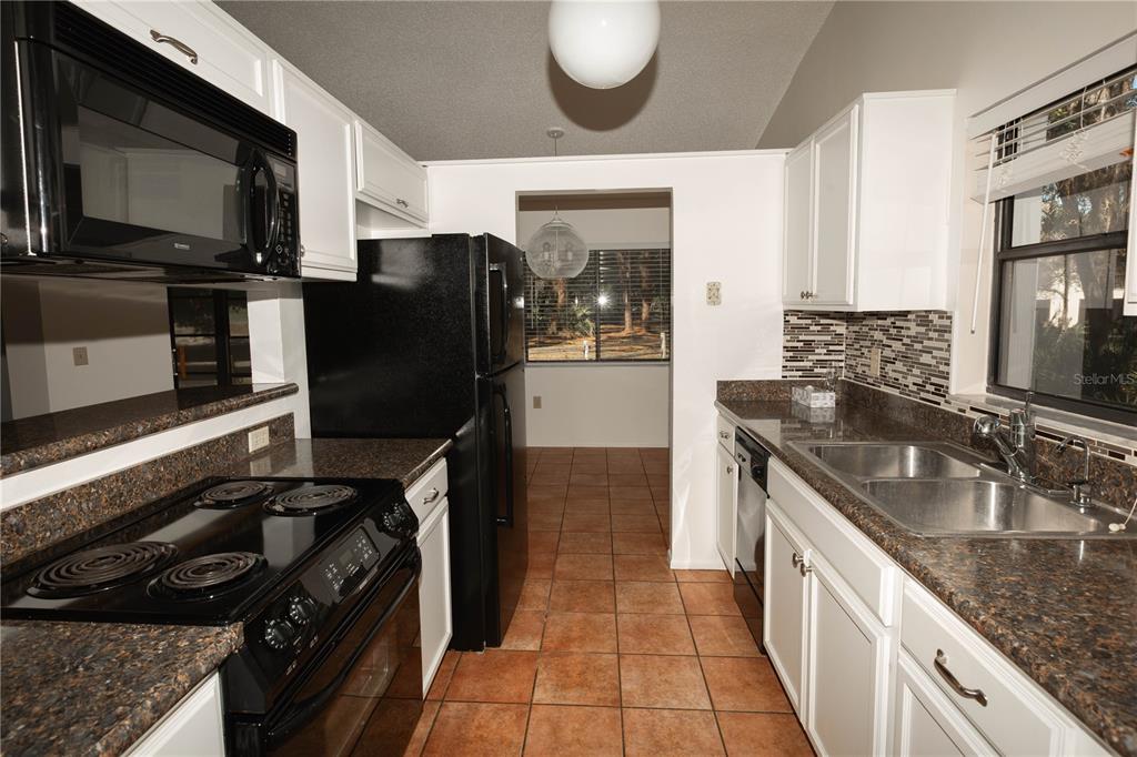 9410 Nakoma Way, Unit H Weeki Wachee, FL 34613 - Photo 16 of 29 a kitchen with stainless steel appliances granite countertop a sink stove and refrigerator