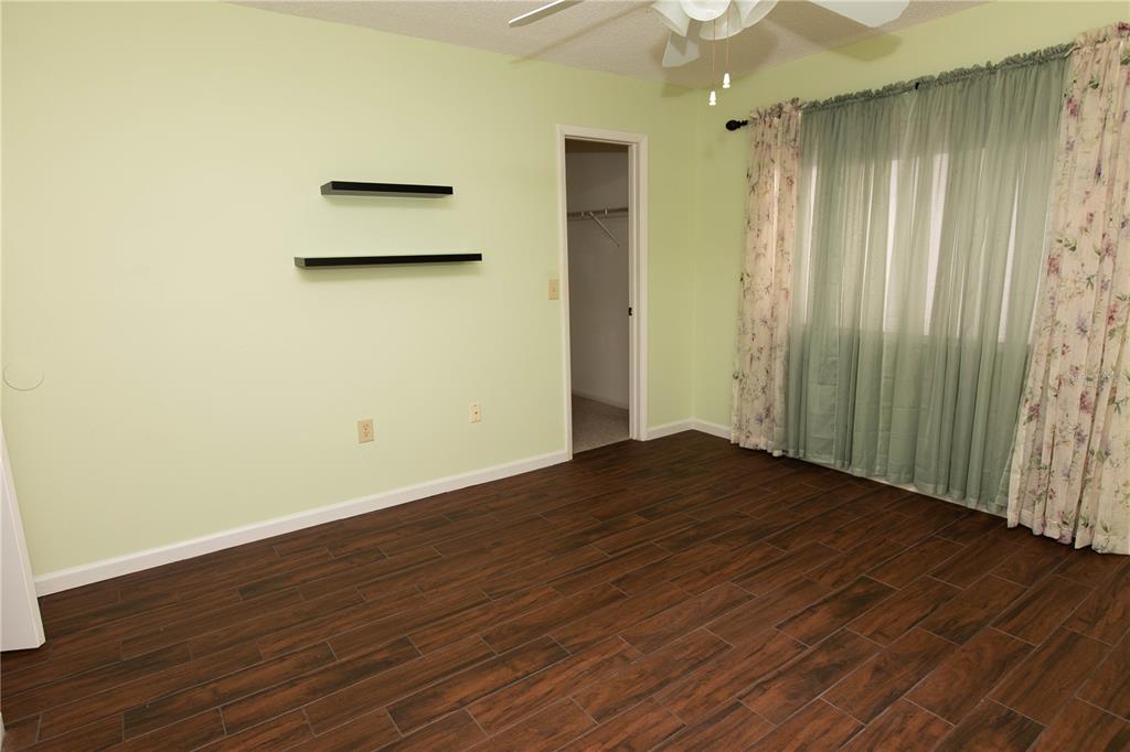 9410 Nakoma Way, Unit H Weeki Wachee, FL 34613 - Photo 18 of 29 an empty room with wooden floor and a window